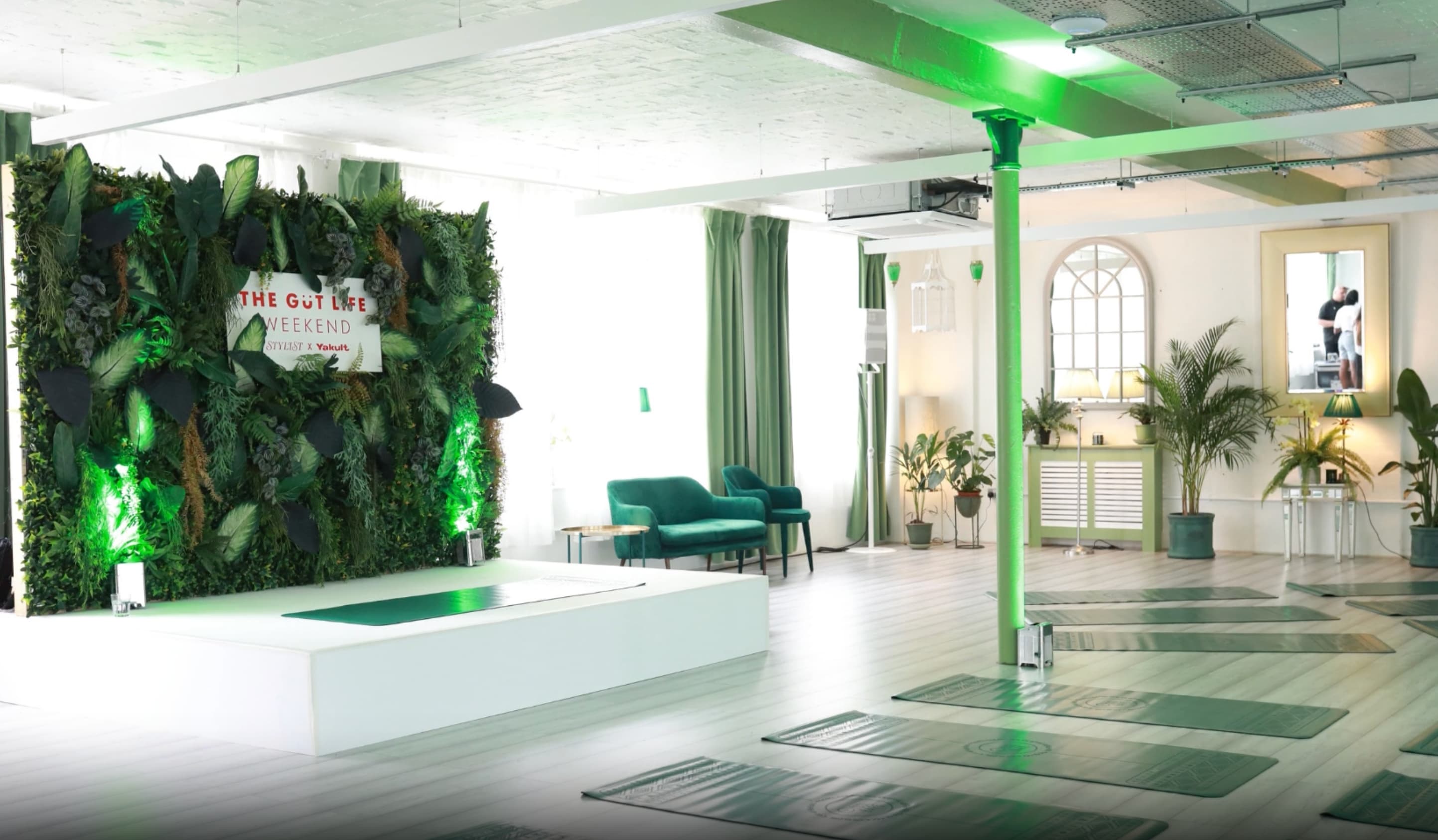 Wellness space with stage and greenery backdrop for fitness event, mindfulness workshop.