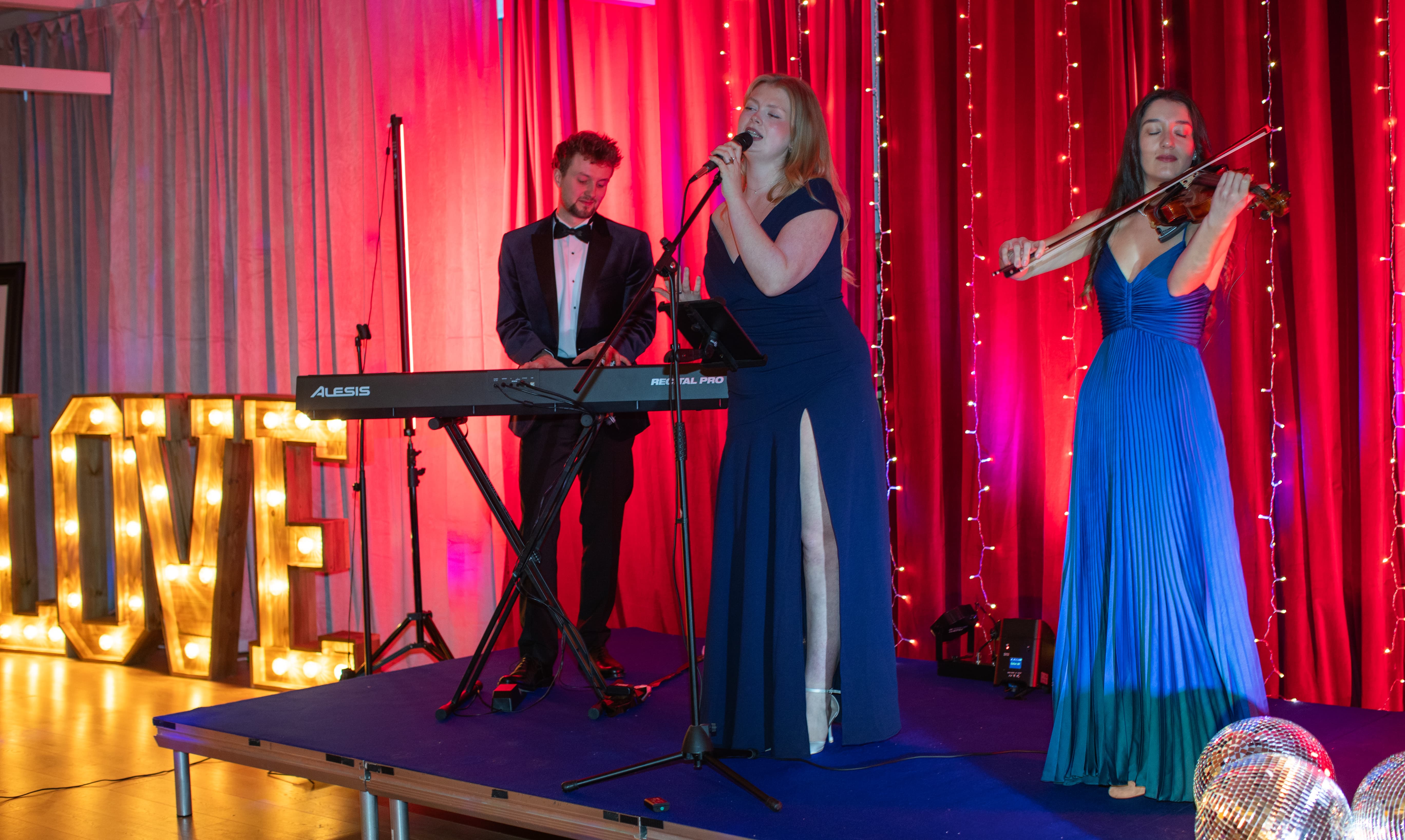 Live entertainment act with ambient lighting for luxury wedding reception or gala dinner.