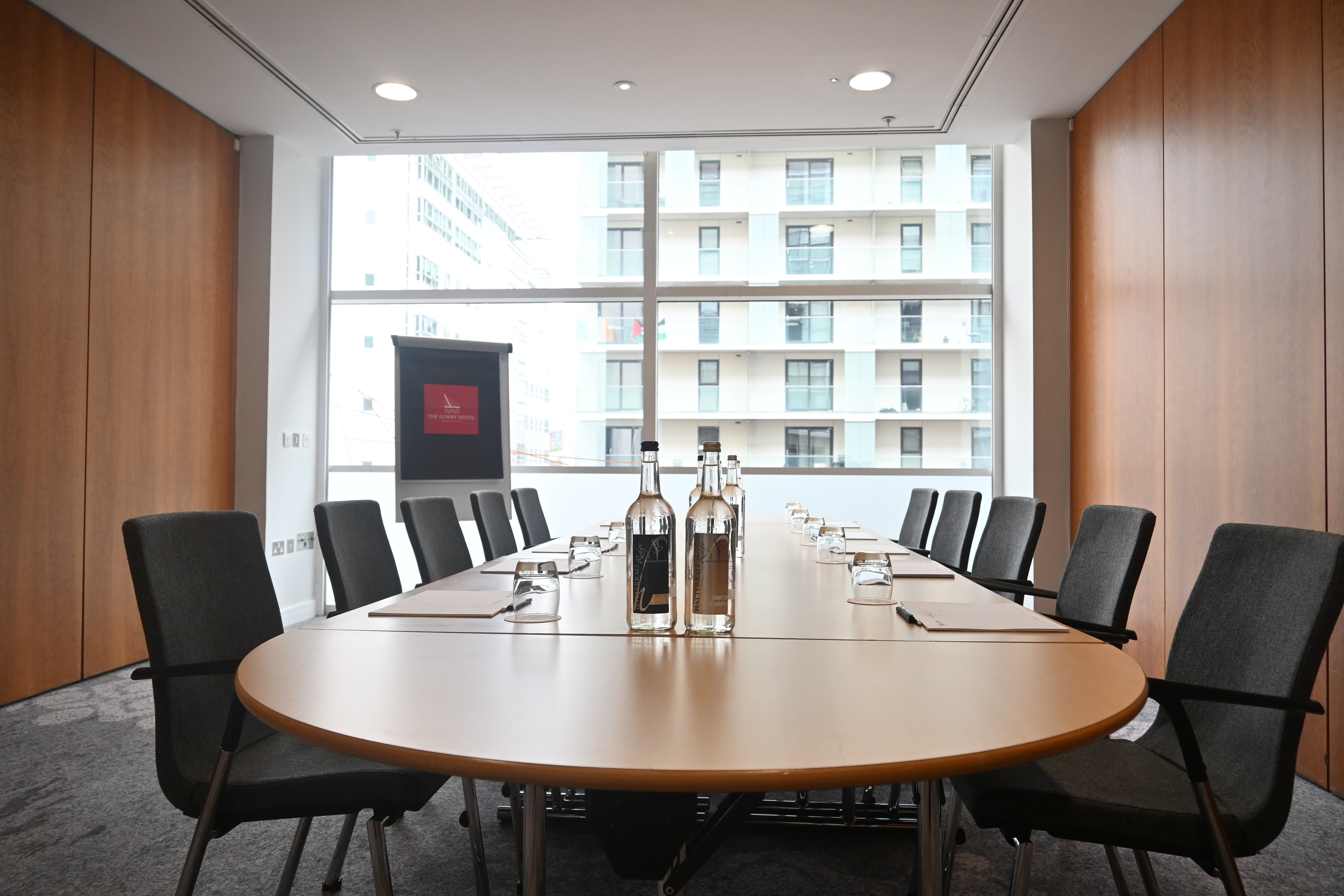 Boardroom-style Meeting Room 3 at The Lowry Hotel with natural light for small business meetings.