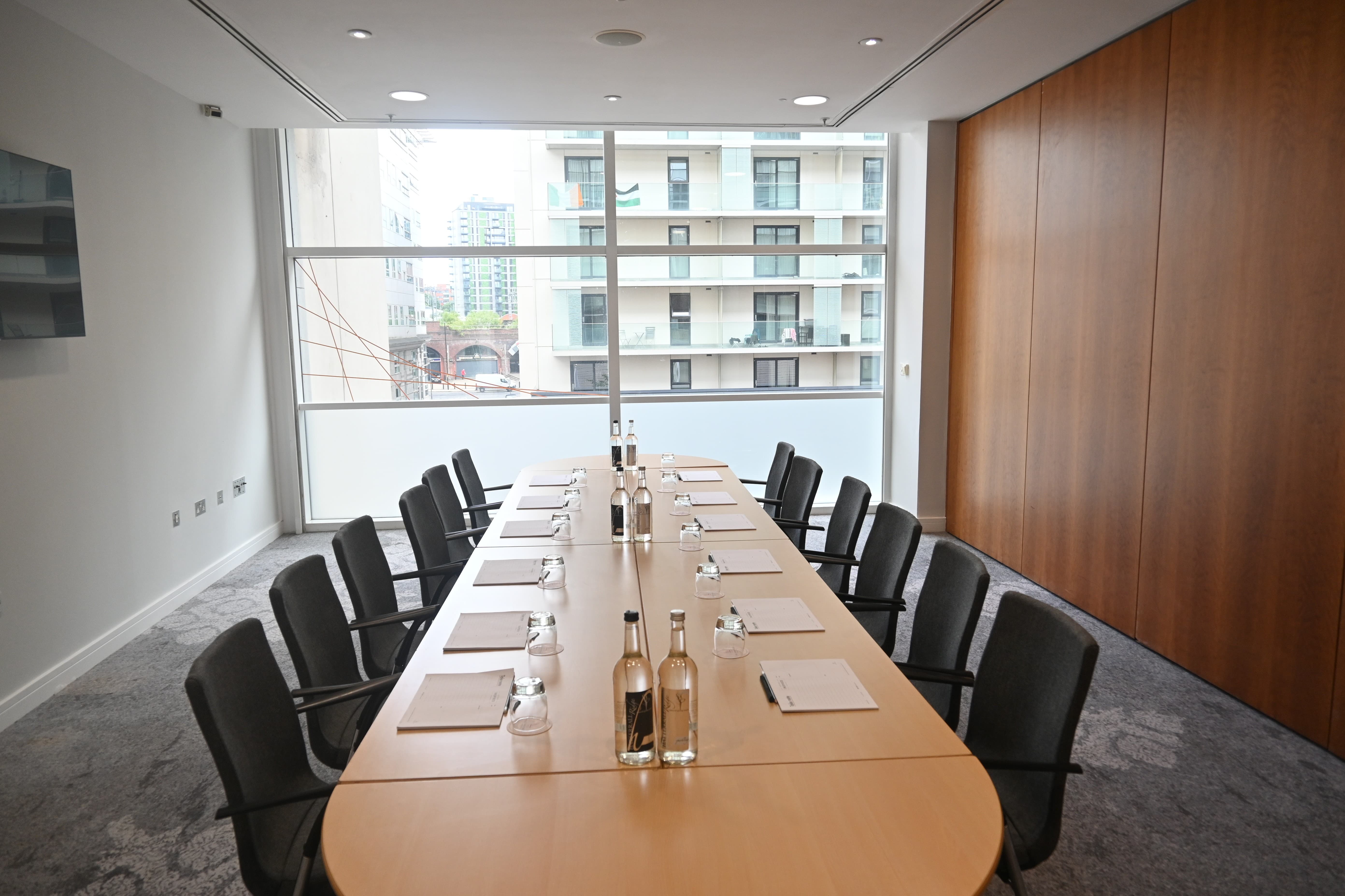 Boardroom setup in The Lowry Hotel Meeting Room 4 with natural light for executive business events.
