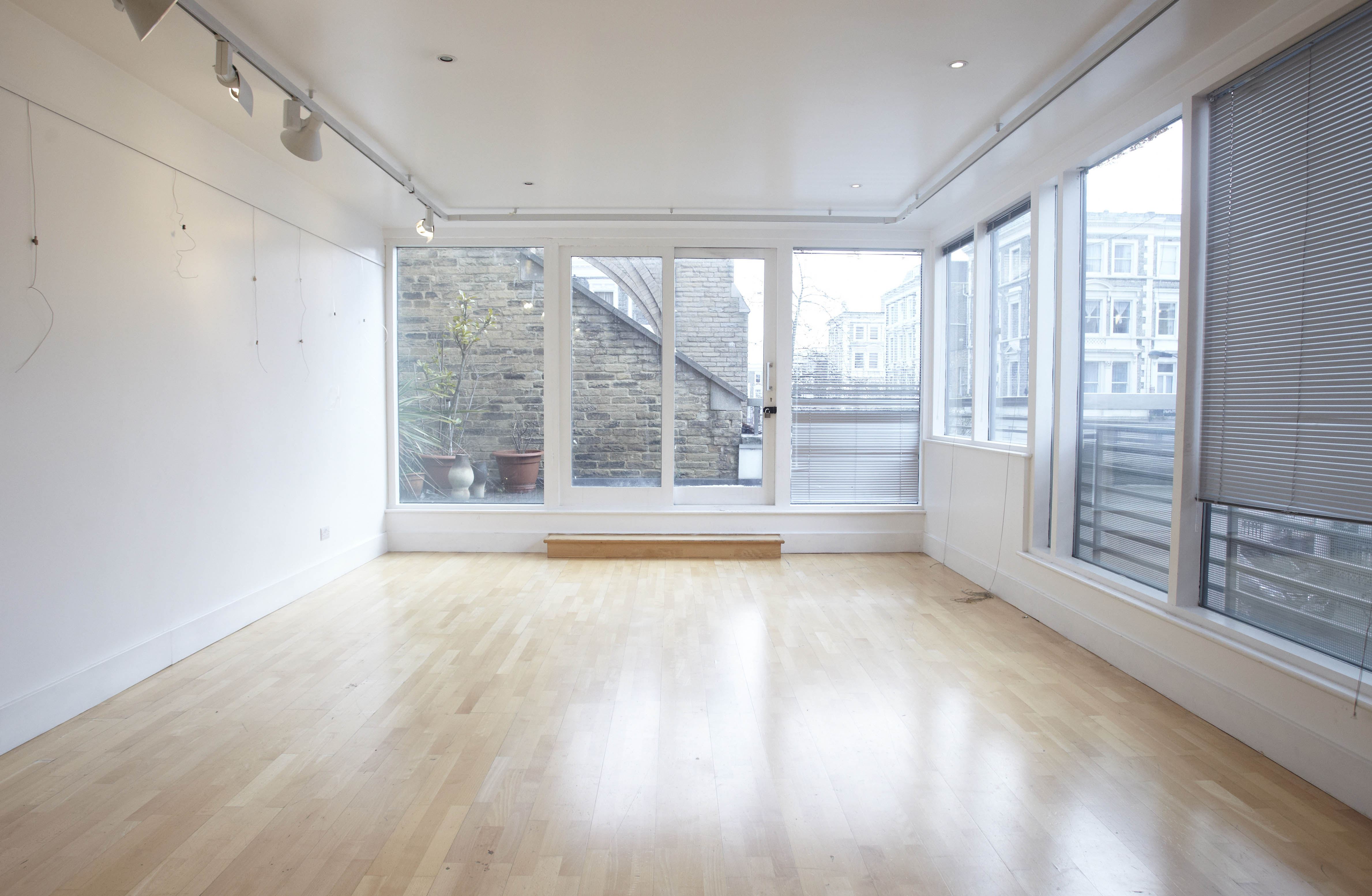 Millennium Art Gallery: bright minimalist event space with large windows for workshops and gatherings.
