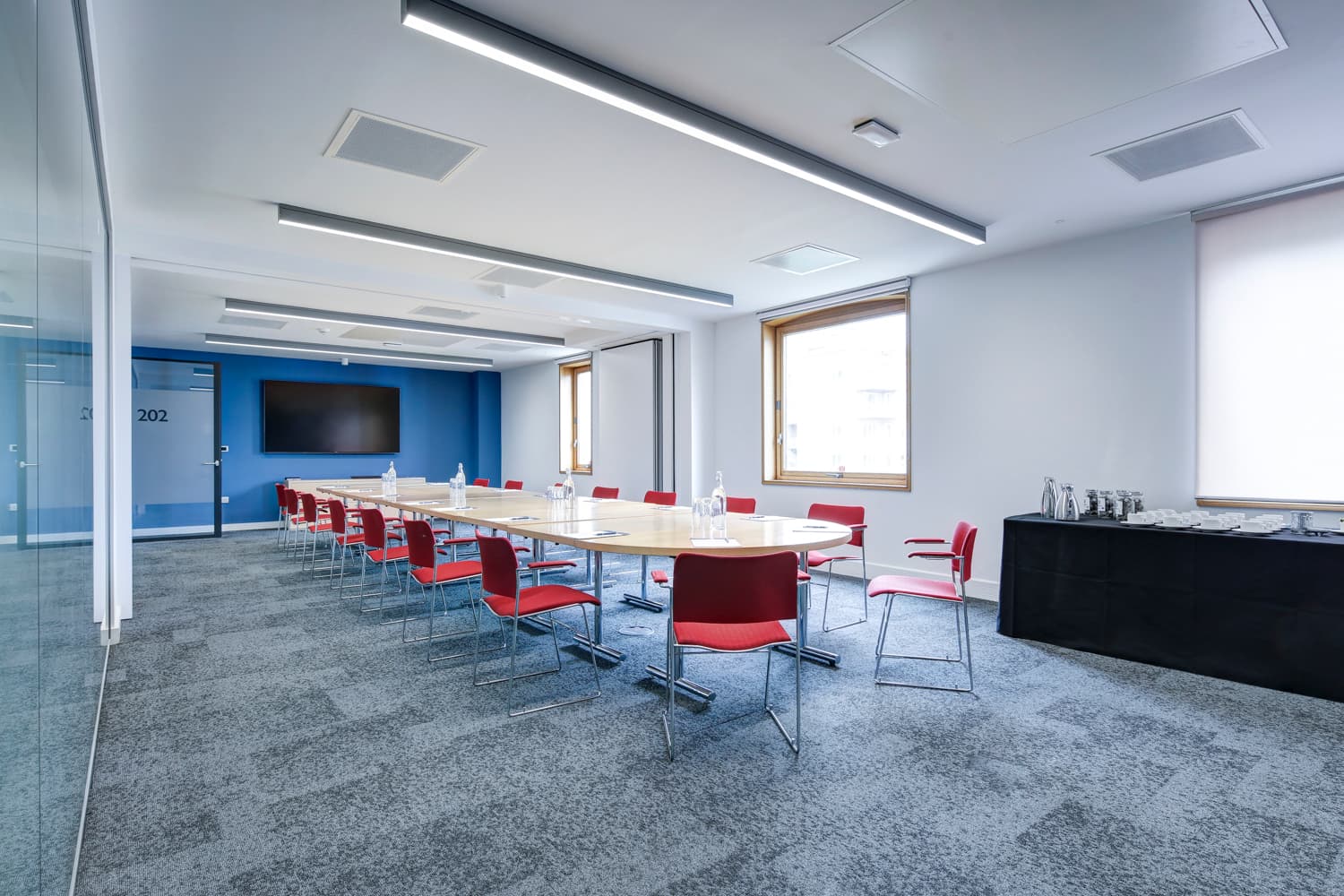 Modern boardroom with hollow-square table for corporate meetings and workshops.