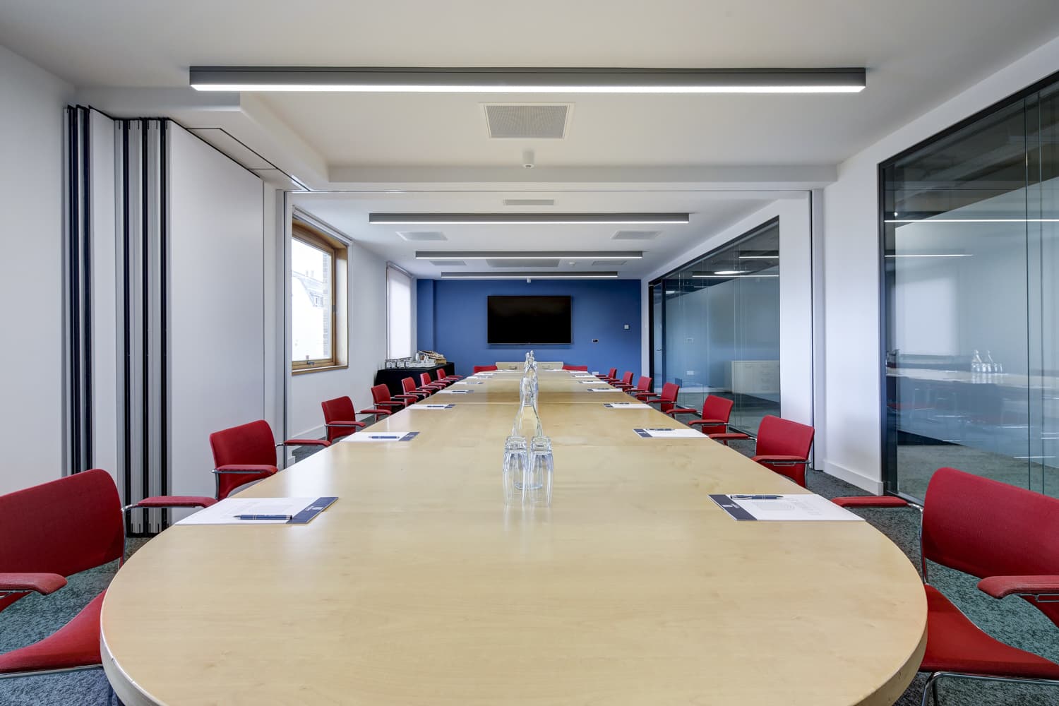 Boardroom at 10 Union Street featuring a wood table and red chairs for business meetings.