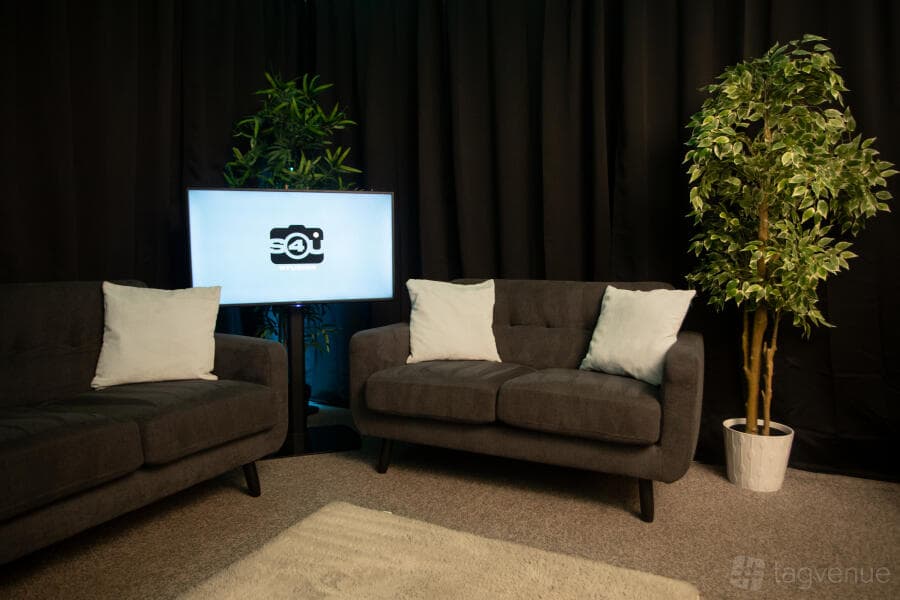 Podcast suite at Qube Acton with modular seating for fireside chats and event branding.