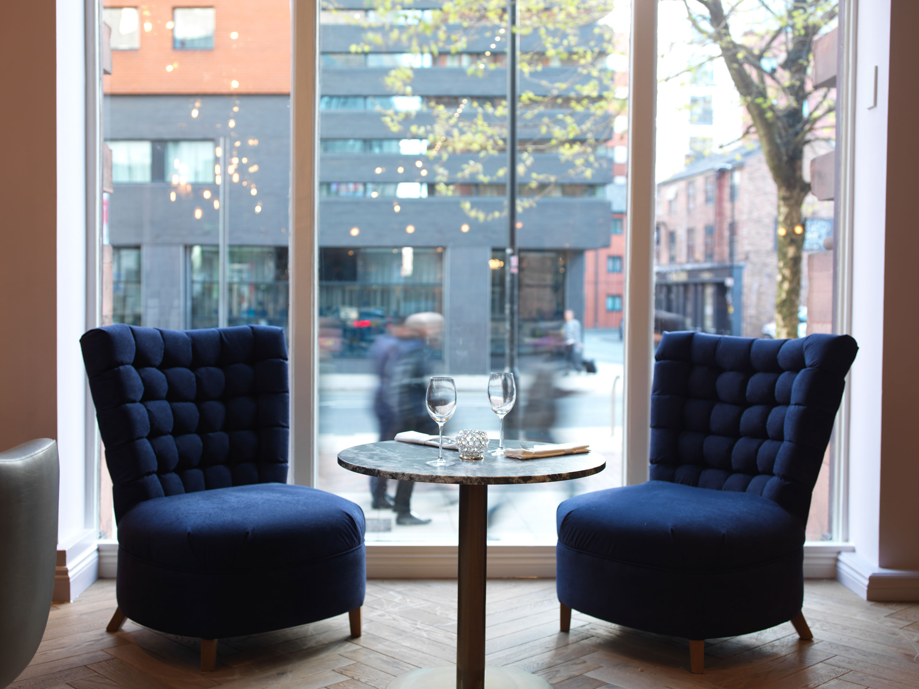 Cozy meeting space with plush blue chairs in ABode Manchester for networking events.