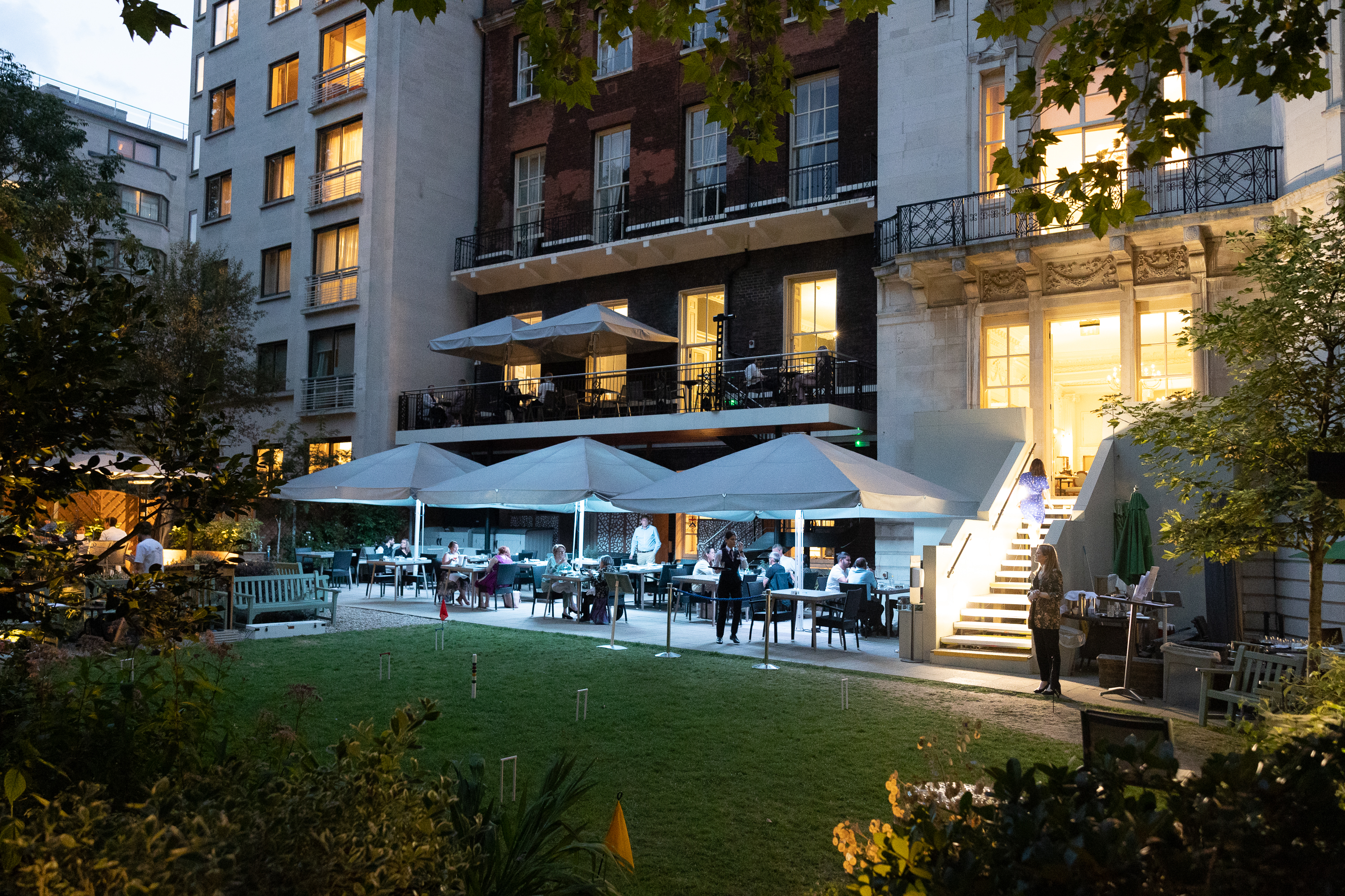 Elegant outdoor event space with lush greenery, perfect for corporate gatherings and celebrations.