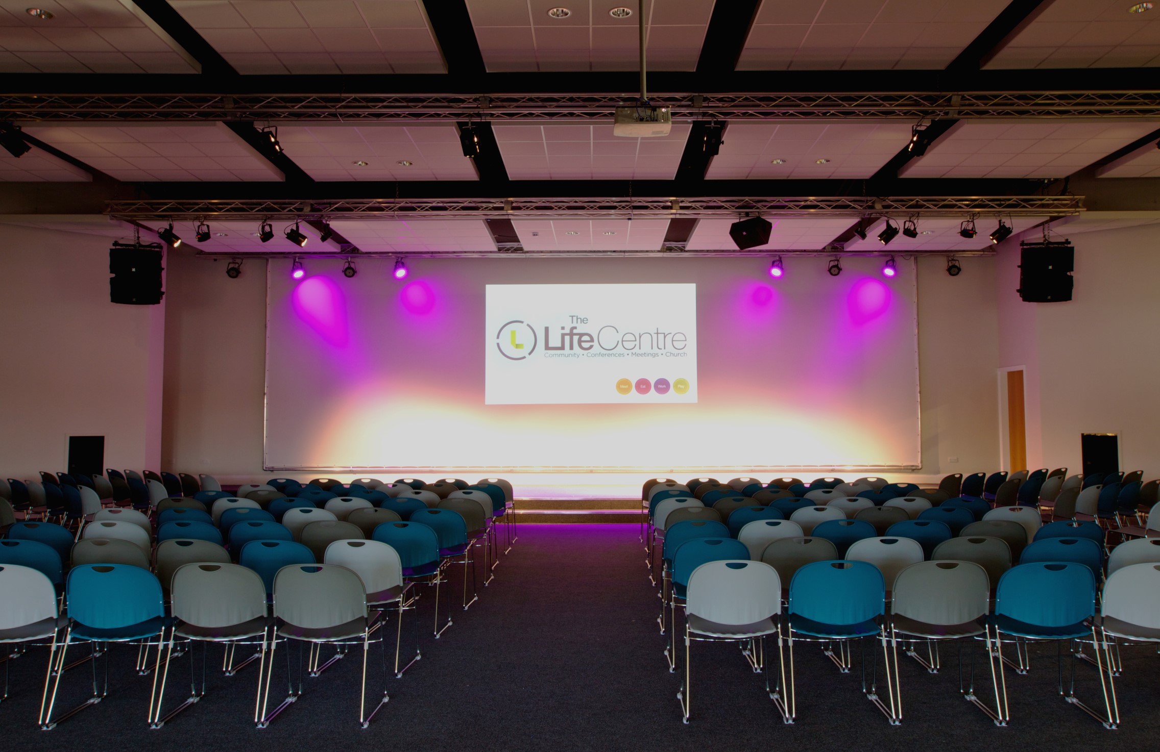 Wesley Hall event space with stage lighting, ideal for conferences and presentations.
