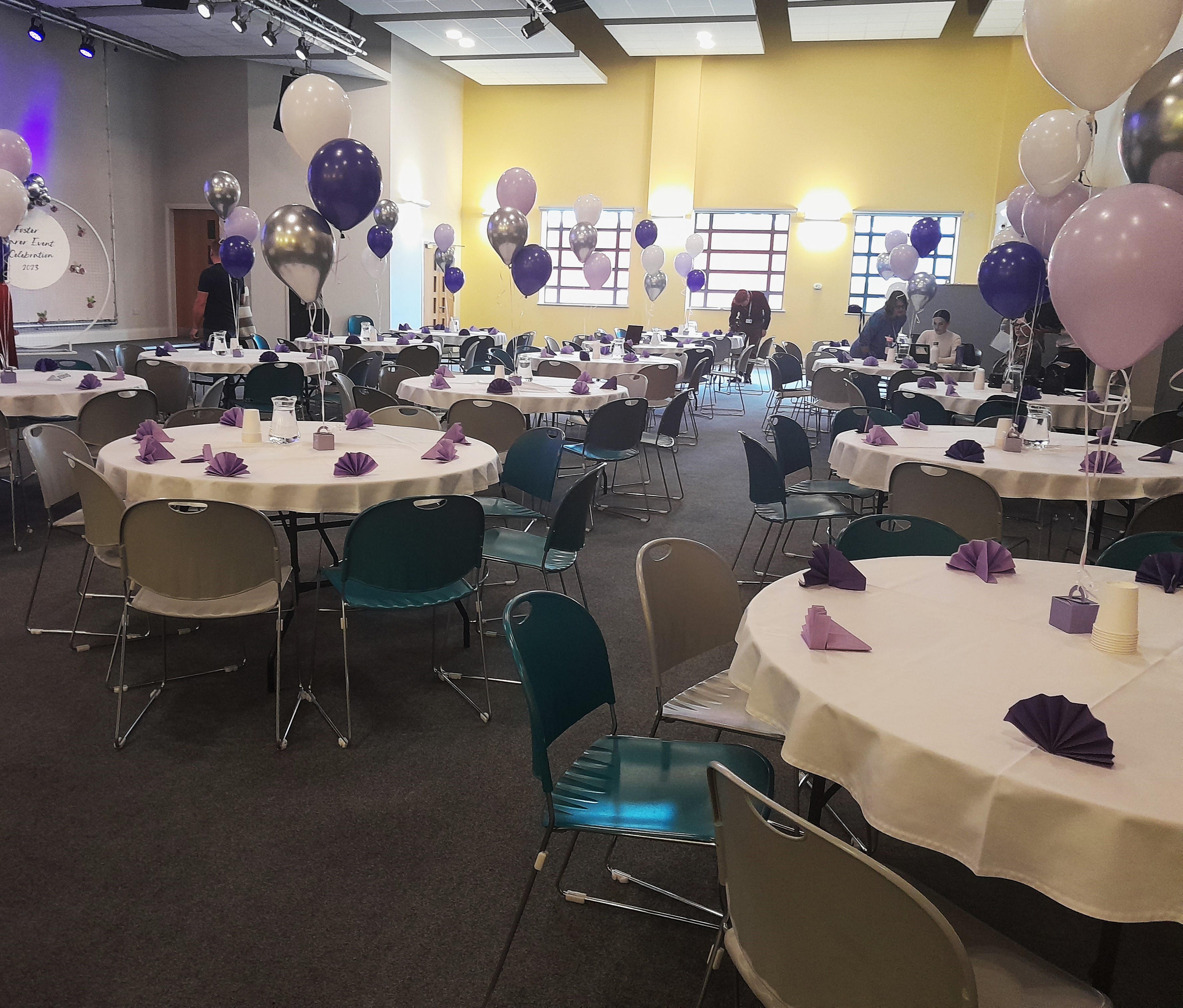 Wesley Hall event space with round tables, purple accents for networking and celebrations.