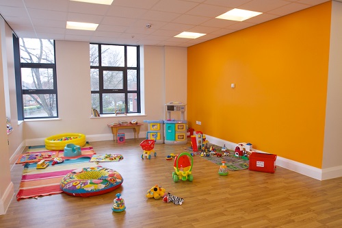 Vibrant Luther King Room playroom for family-friendly events with bright orange accents.