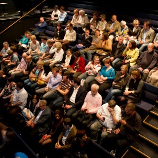 Diverse audience at Main House Theatre, Soho, eagerly awaiting an engaging event.