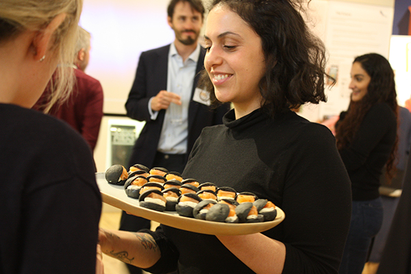 Networking event at Museum of Brands with sushi platter and smiling server.