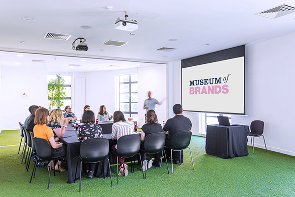 Modern conference room with round table and large screen, perfect for workshops.