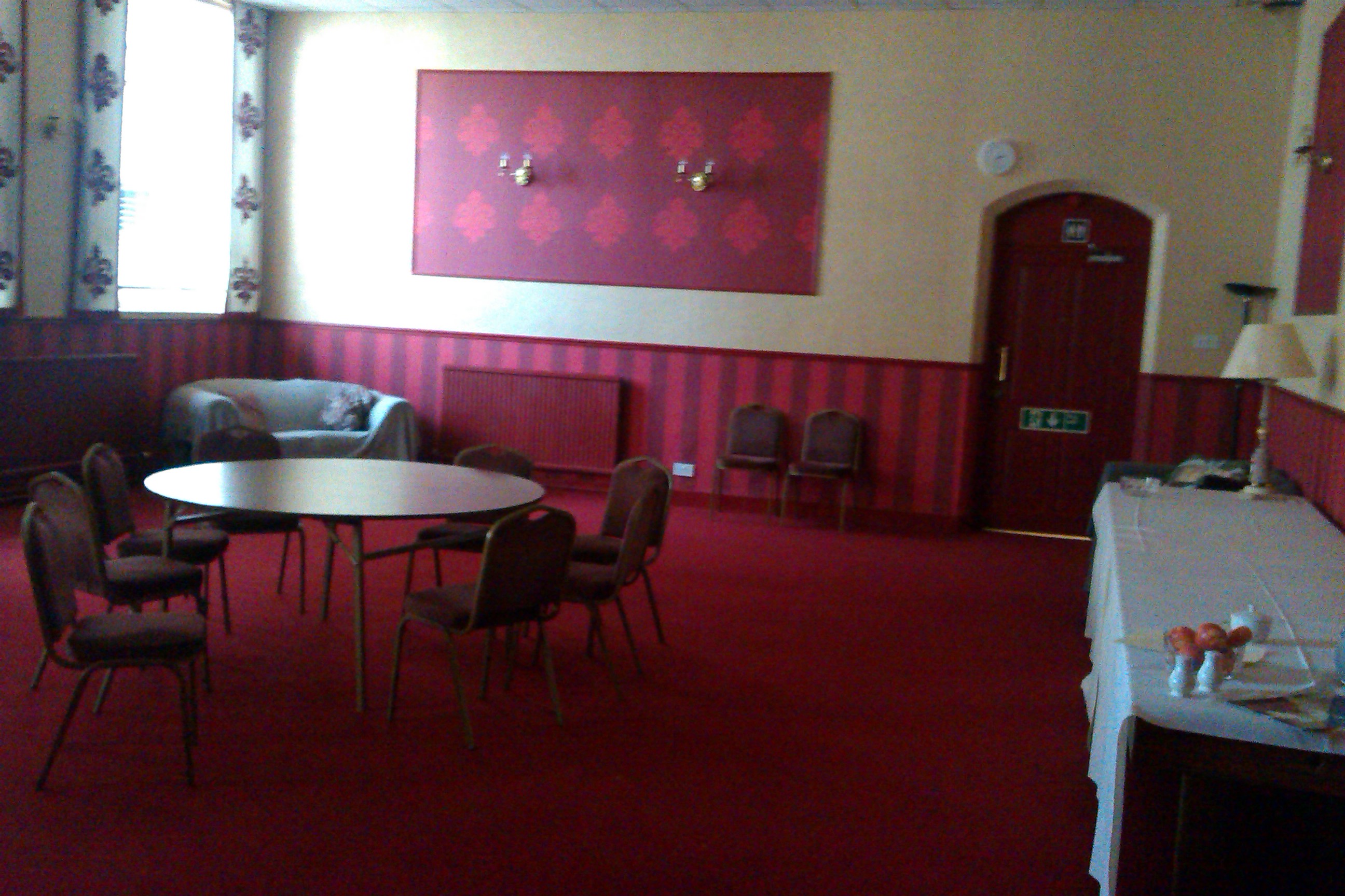 Intimate meeting room with circular table at Hedley Lodge, perfect for workshops and discussions.