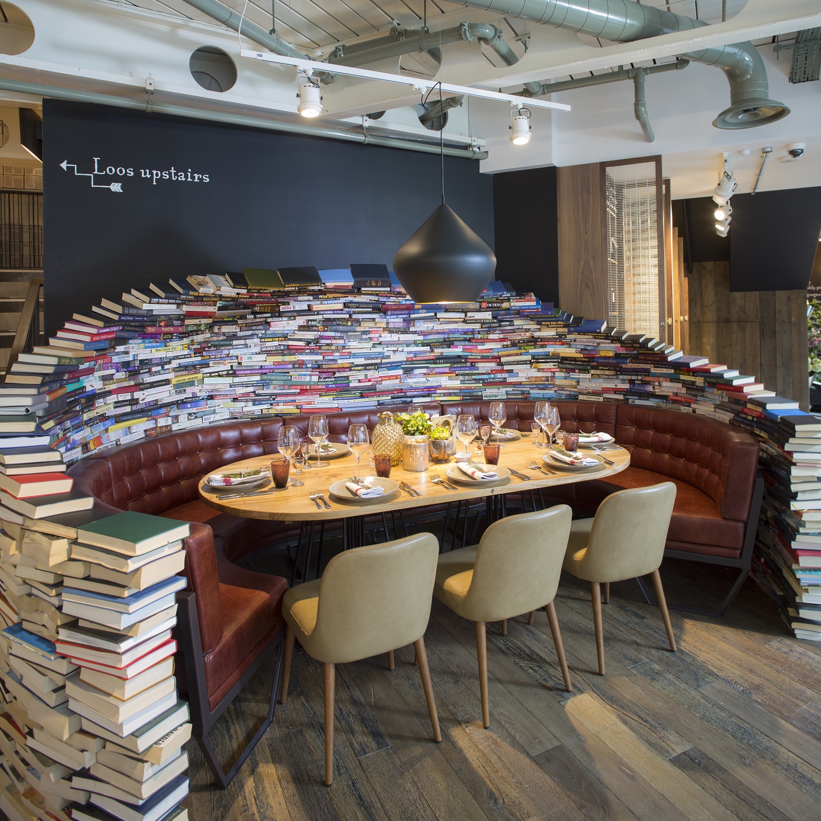 Creative dining space with book wall, ideal for private dinners and networking events.