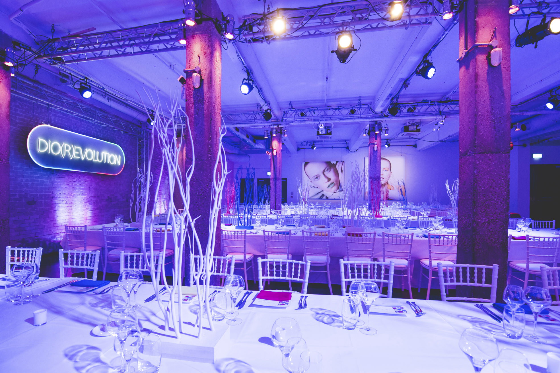 Stylish event space with elegant table settings and ambient purple lighting for branding events.