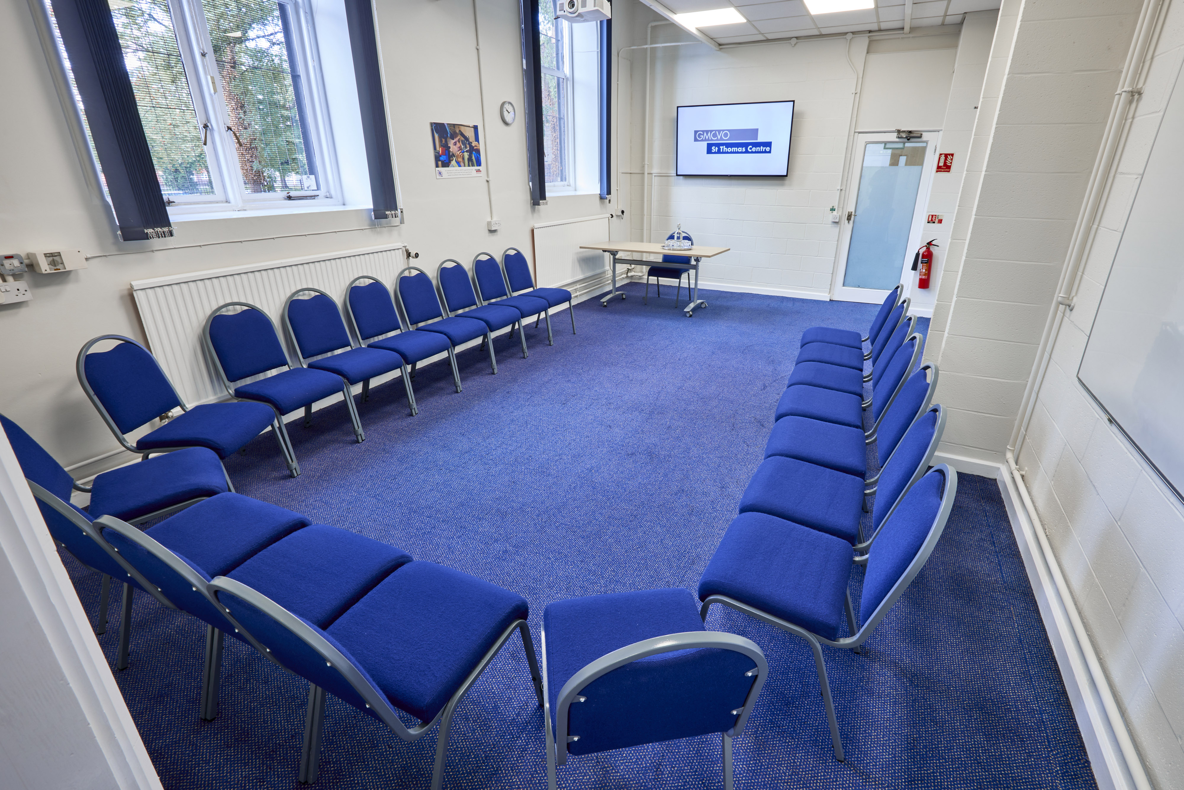 Gaskell Room at St Thomas Centre: bright meeting space with blue chairs for workshops.