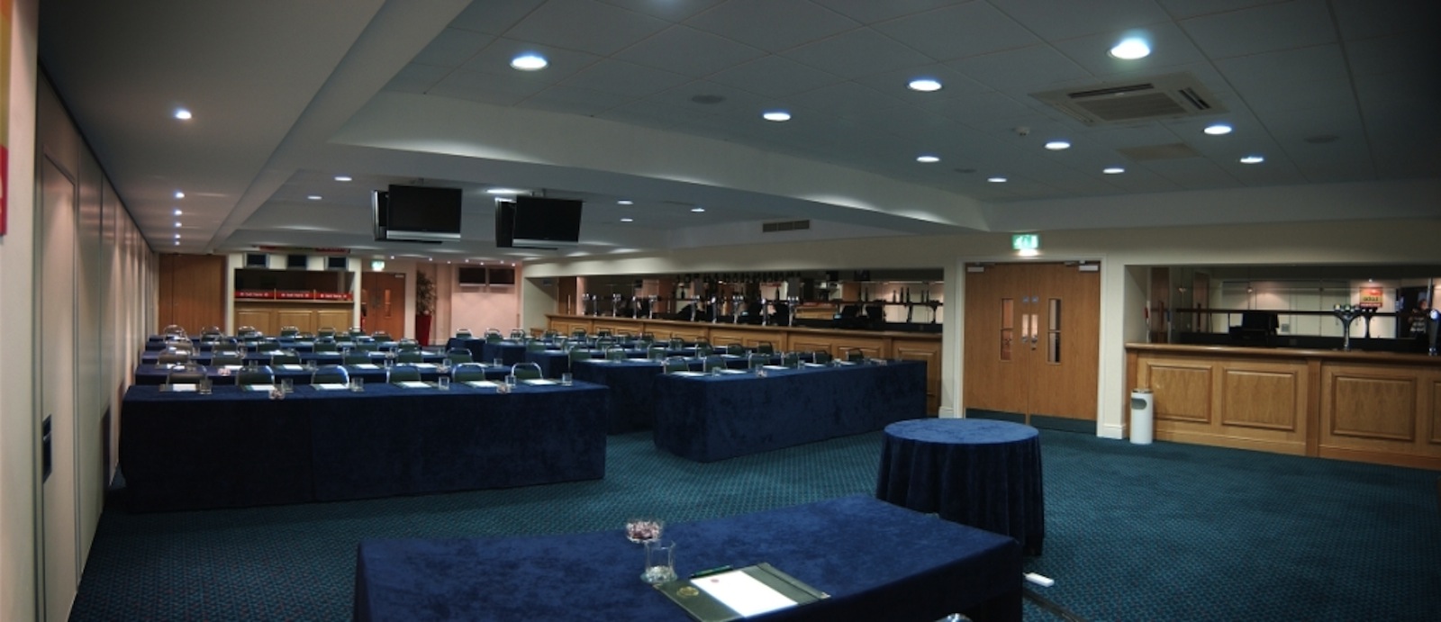 Horseshoe Suite at Haydock Park: conference room with blue tablecloths and screens.