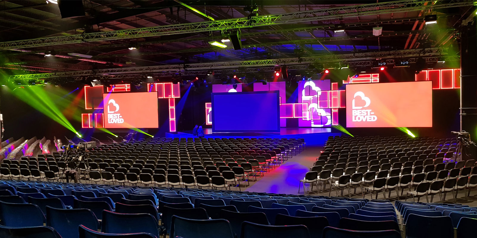"Hall 4 at EventCity: spacious conference venue with vibrant stage lighting and seating."