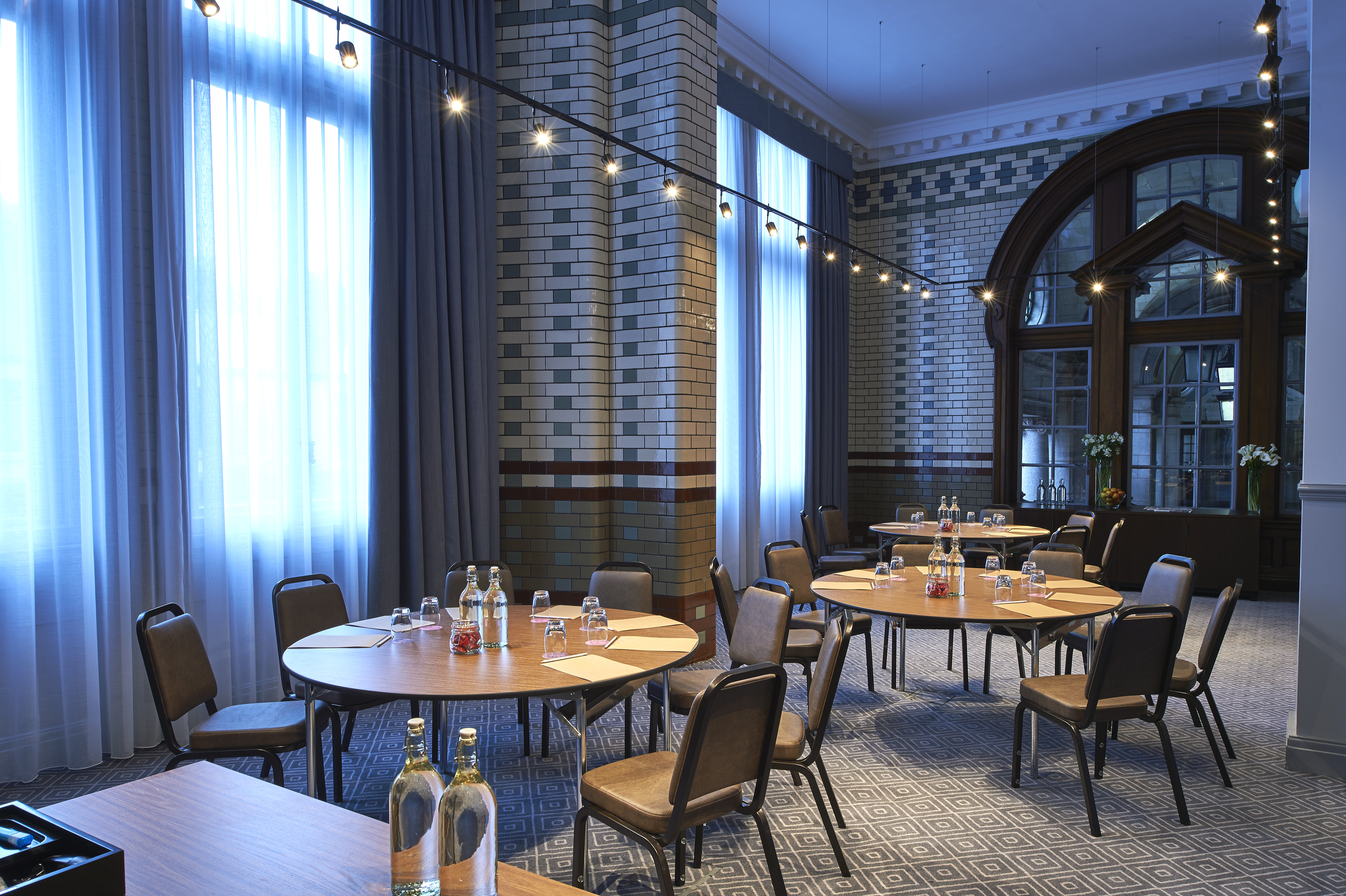Elegant meeting space with round tables at Kimpton Clocktower Hotel for workshops and conferences.