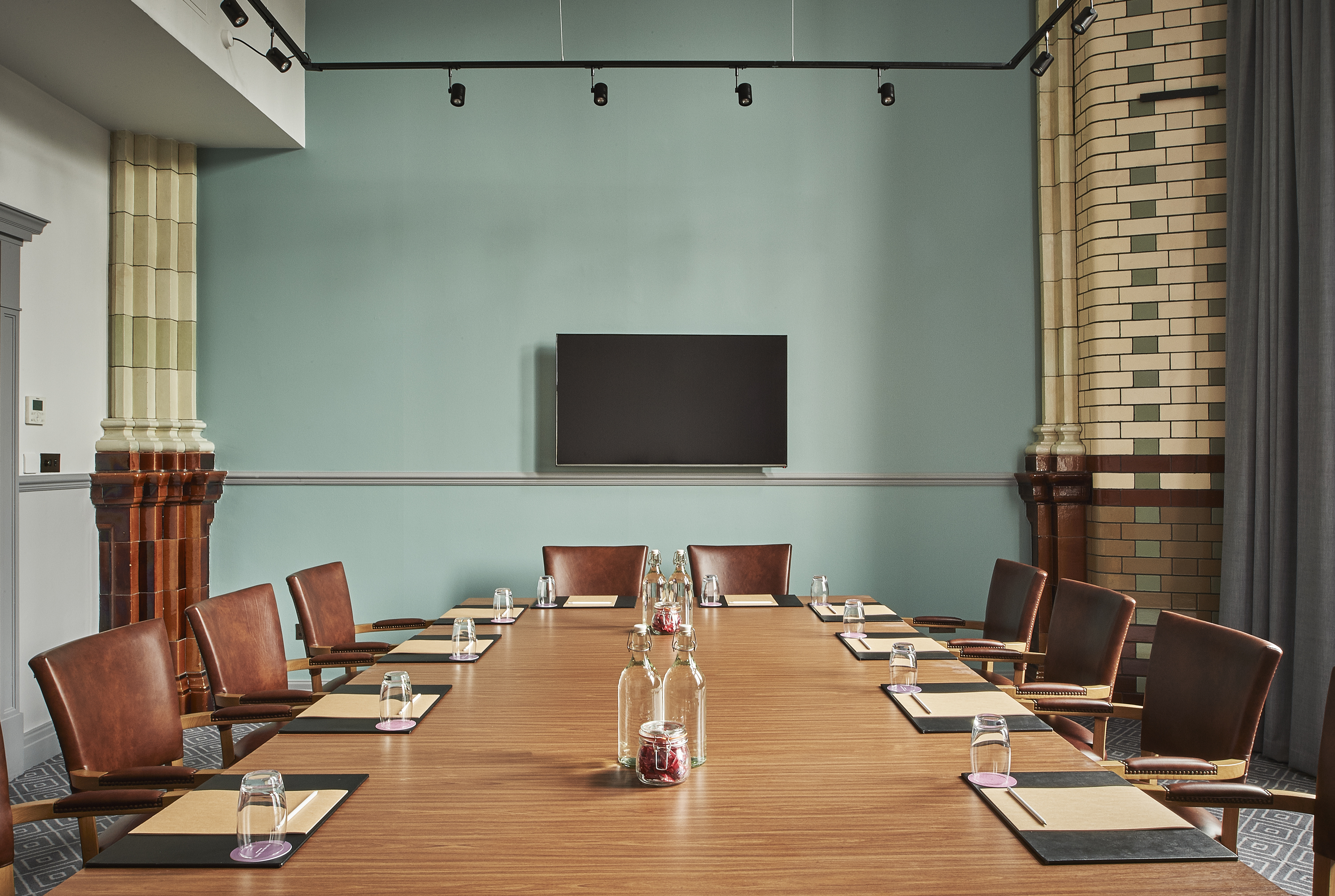 Meeting room at Kimpton Clocktower Hotel, featuring a long wooden table for professional events.
