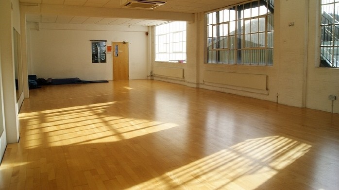 Spacious STUDIO 3 with polished floors, ideal for workshops and yoga classes.