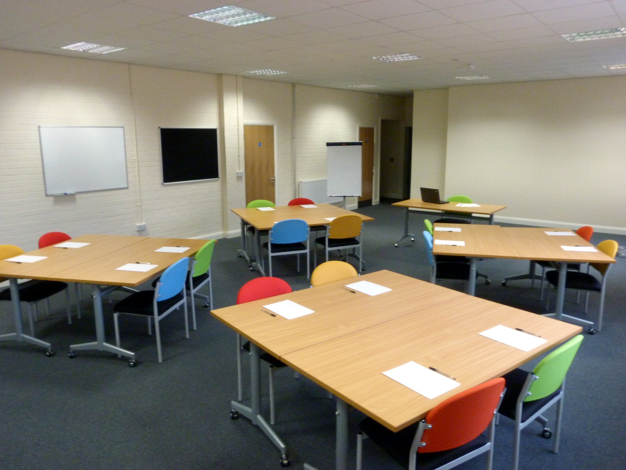 Versatile training room with colorful chairs, ideal for workshops and collaboration.
