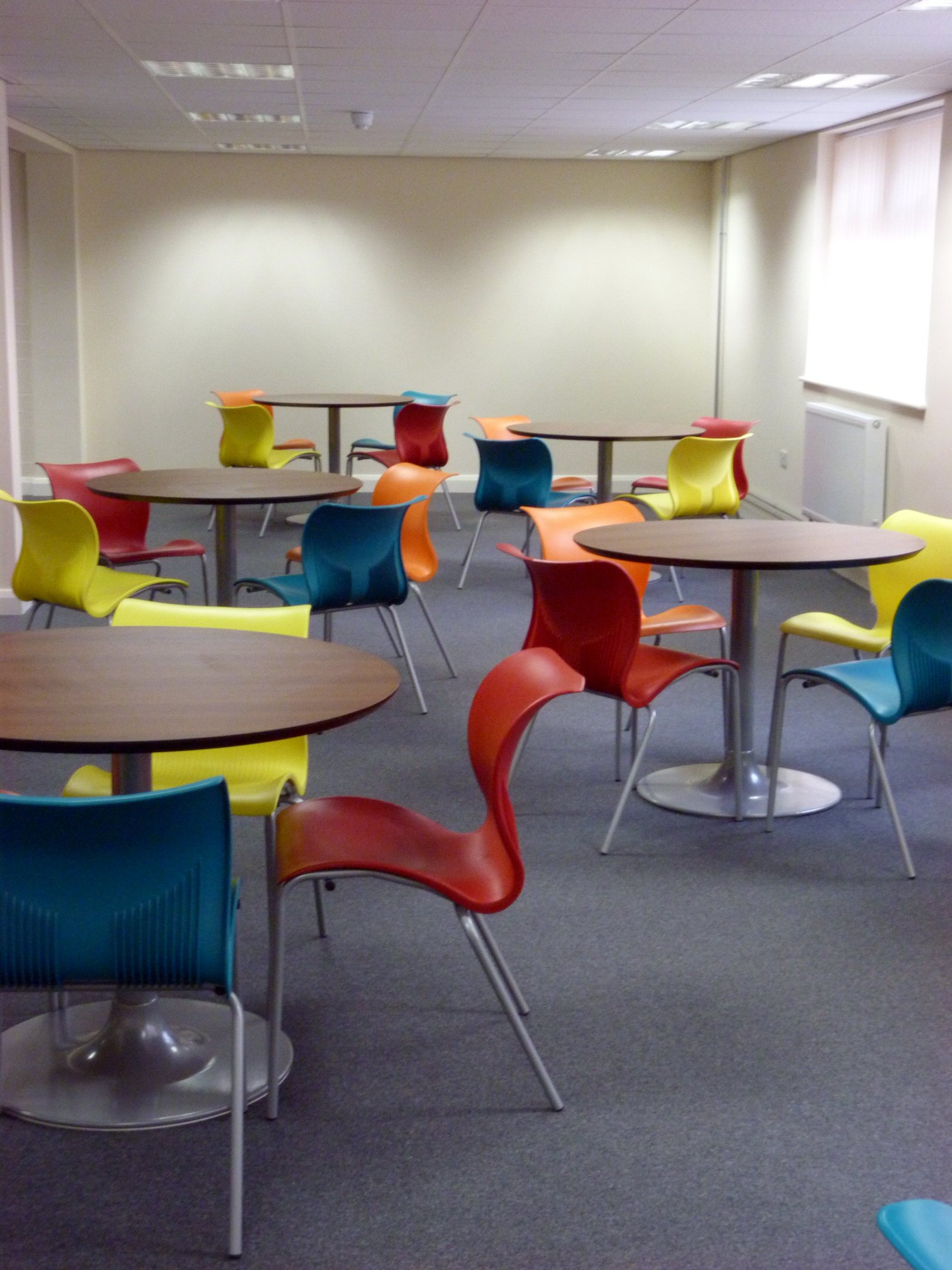Versatile training room with colorful chairs, ideal for workshops and gatherings.
