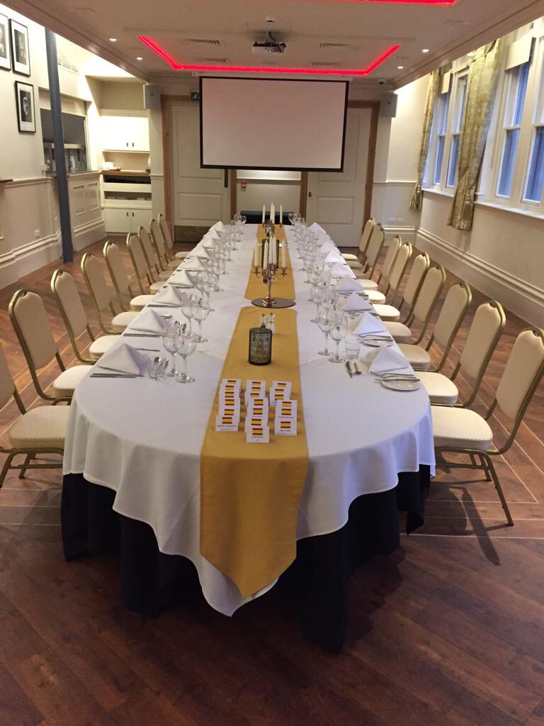 Elegant banquet table with gold runner for formal events and corporate dinners.