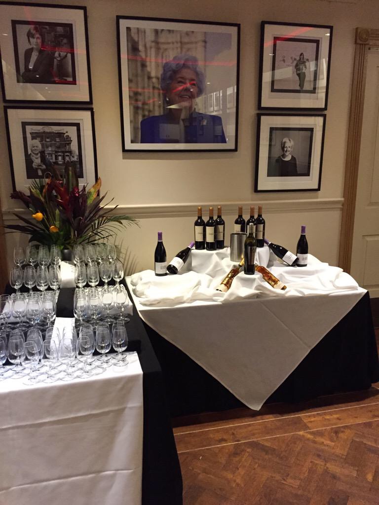 Elegant meeting space at The Restaurant in Fountain House with framed portraits and wine bottles.