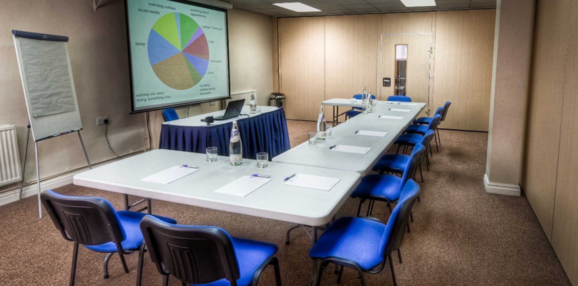 Seminar Room 4 at King's House: organized meeting space with blue chairs for professional events.