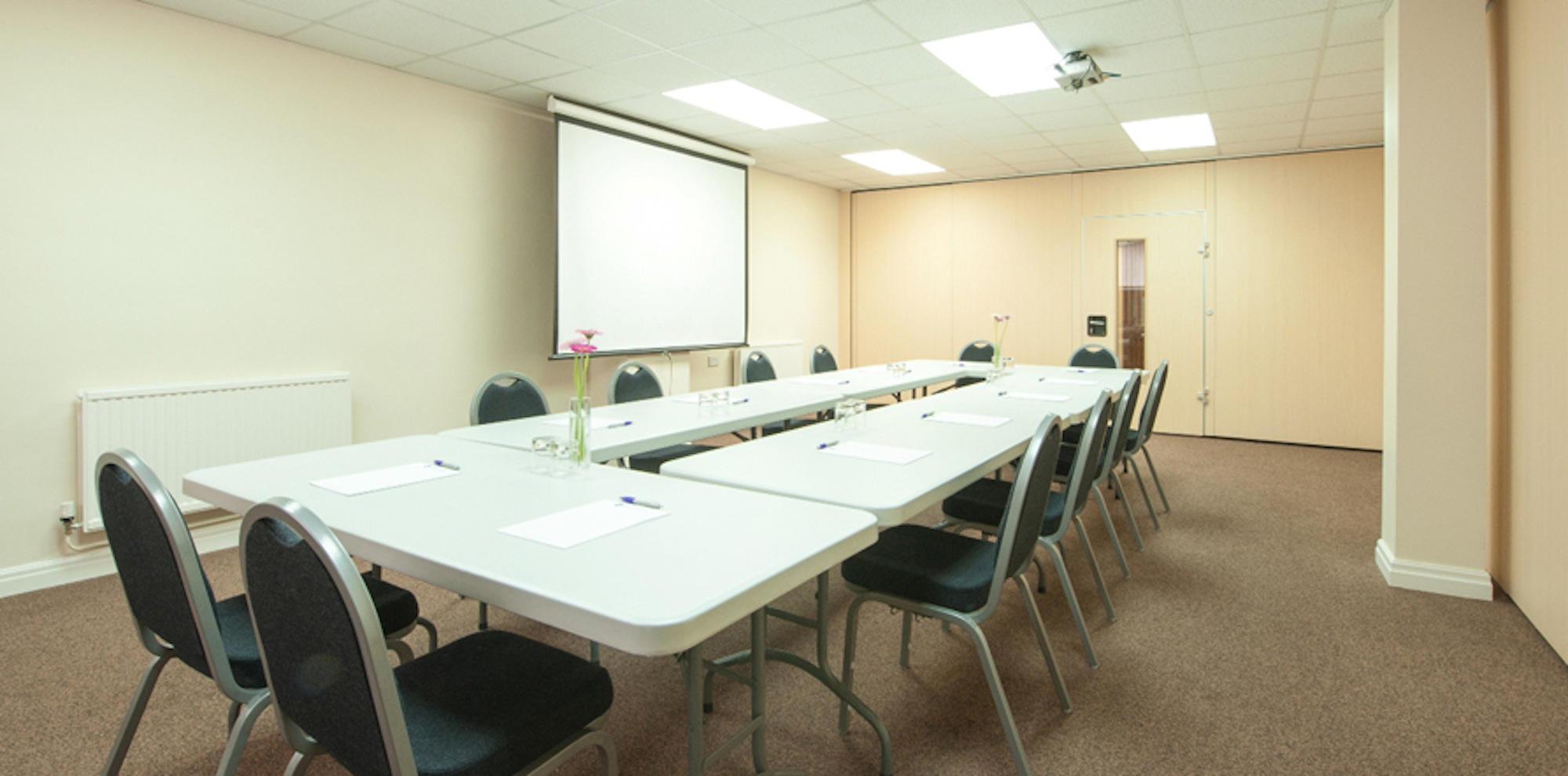 Seminar Room 4 at King's House: organized meeting space with projector for conferences.