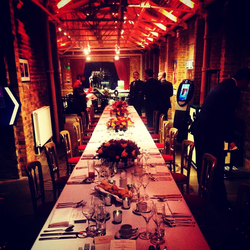Elegant dining setup with floral centerpieces at Tower Bridge for networking event.