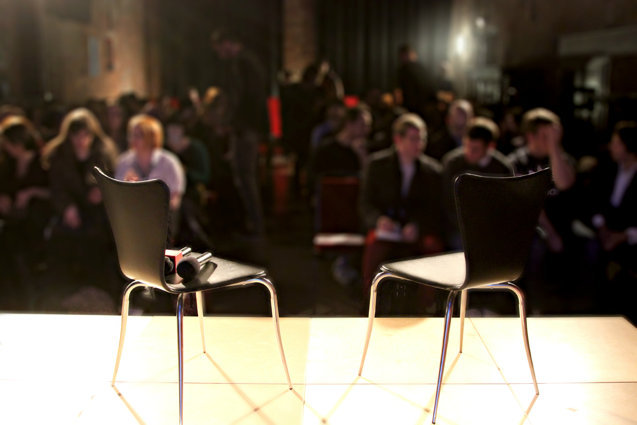 Engine House stage with two empty chairs for engaging discussions at The Burgess Foundation.