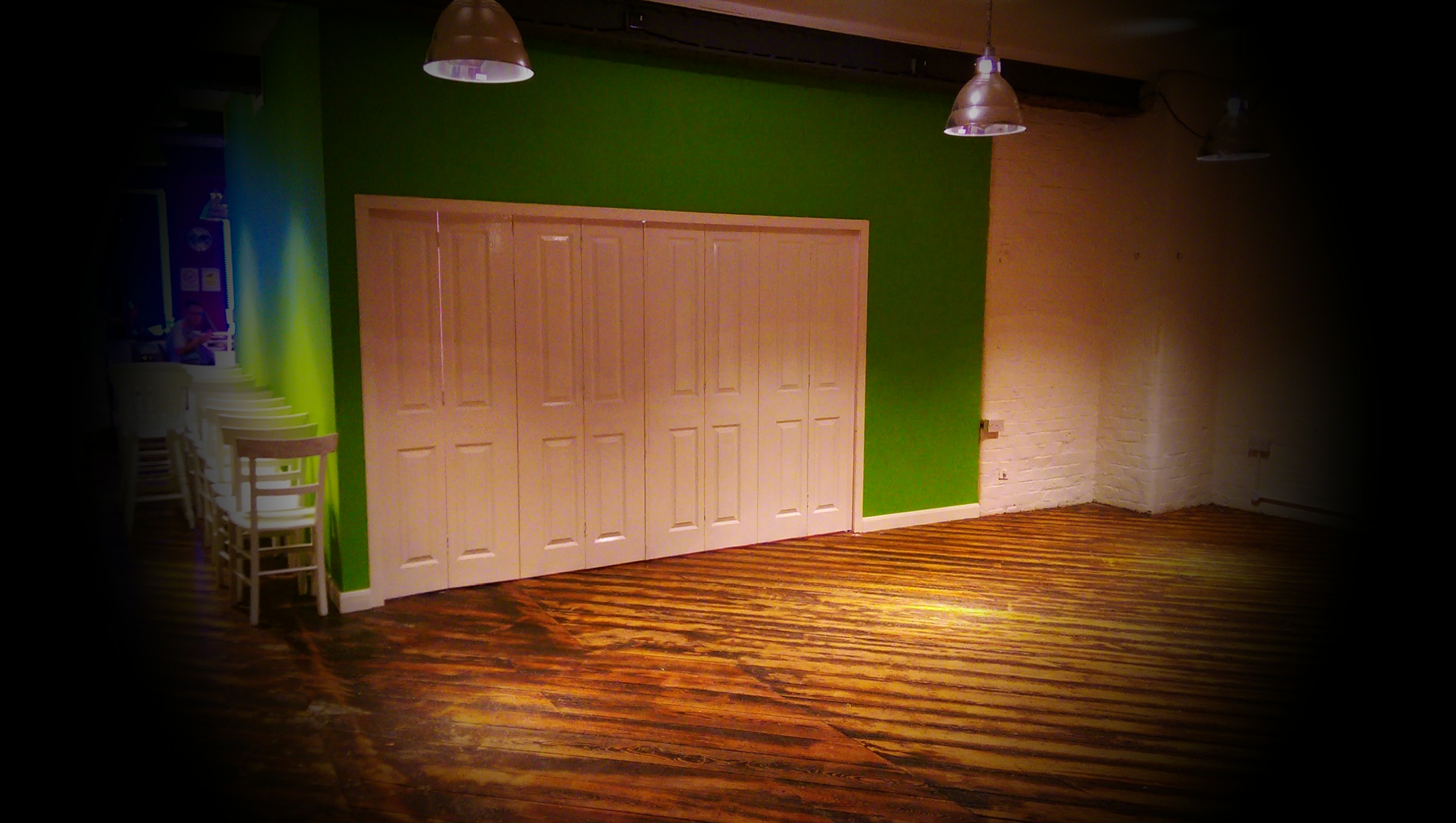 Versatile event space with green accent wall for creative meetings and workshops.