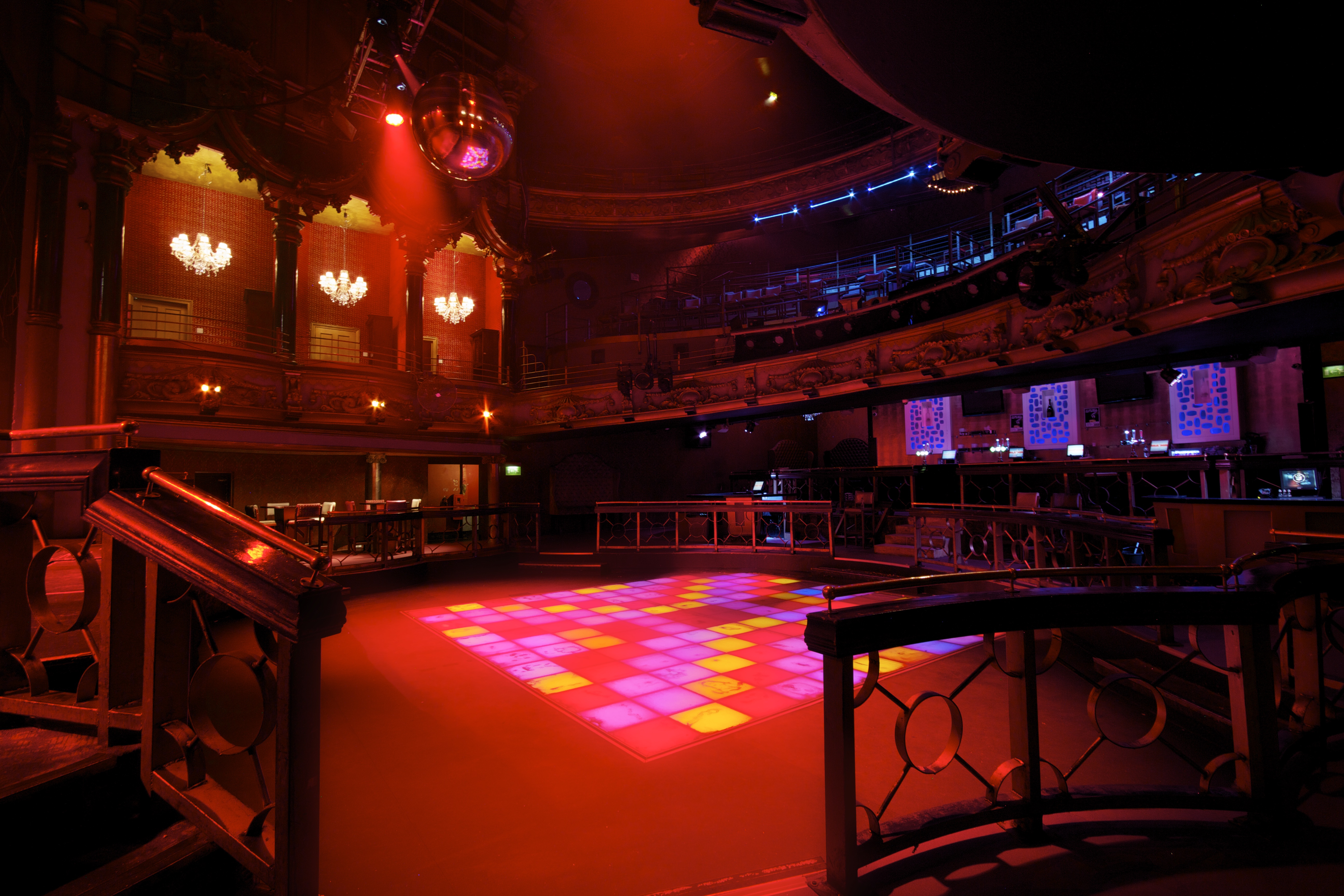 Vibrant event space with dance floor and disco ball for corporate and social gatherings.