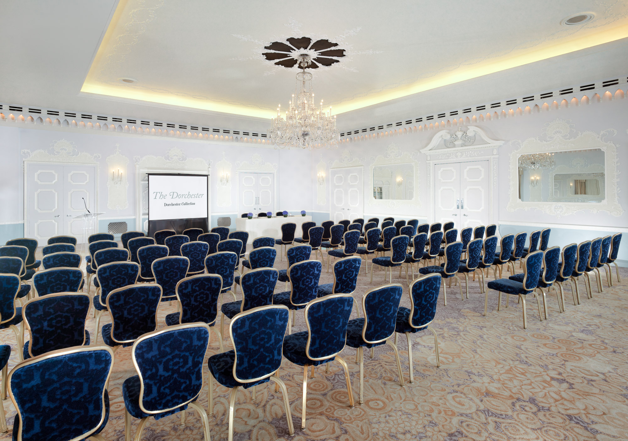 Sophisticated conference space at The Dorchester with elegant blue chairs and soft lighting.