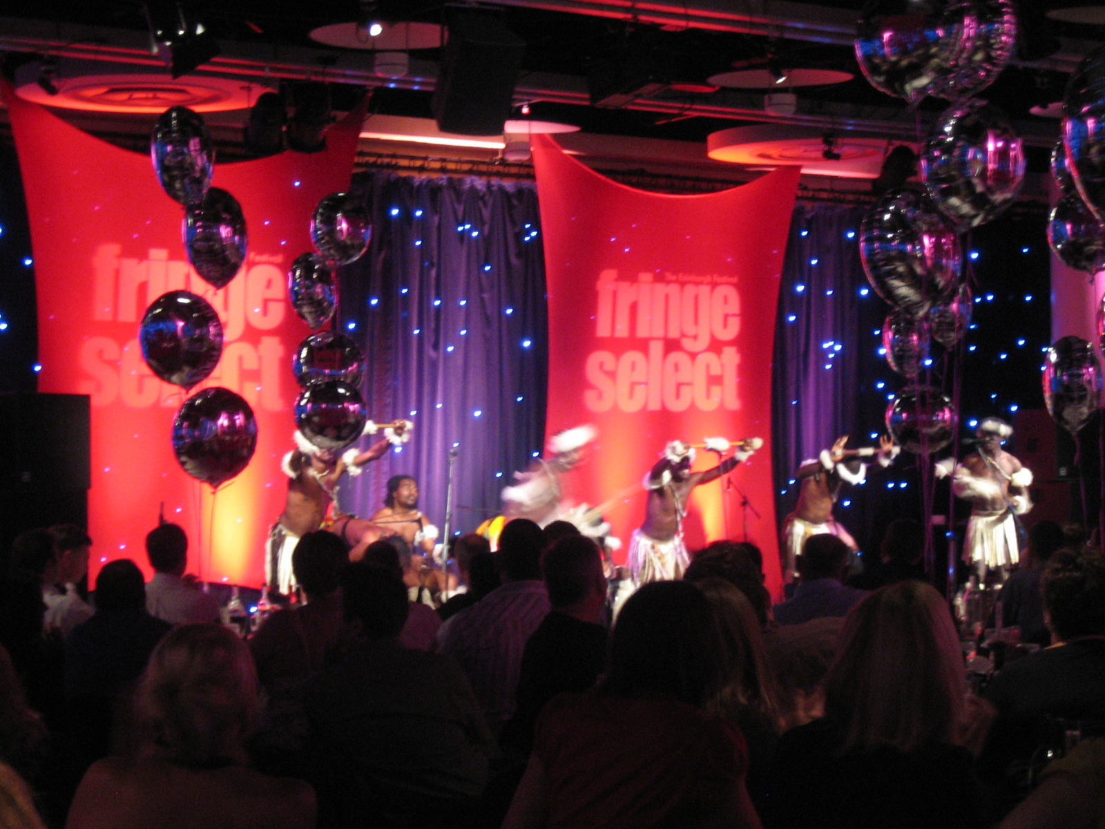 Cromdale Hall event with dynamic performers, red backdrop, networking and entertainment.