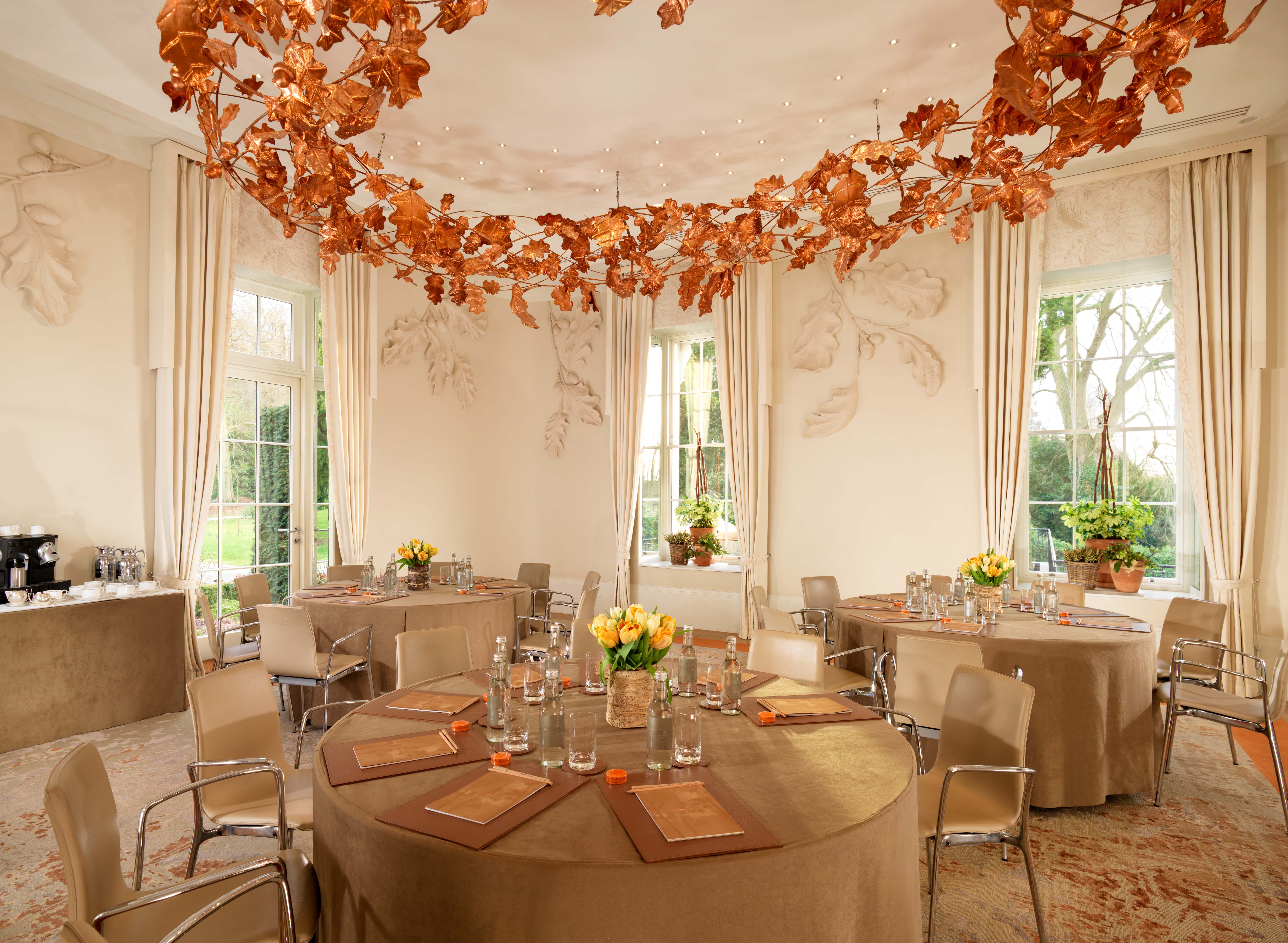 Elegant Oak Room at Coworth Park with floral centerpieces for upscale events.