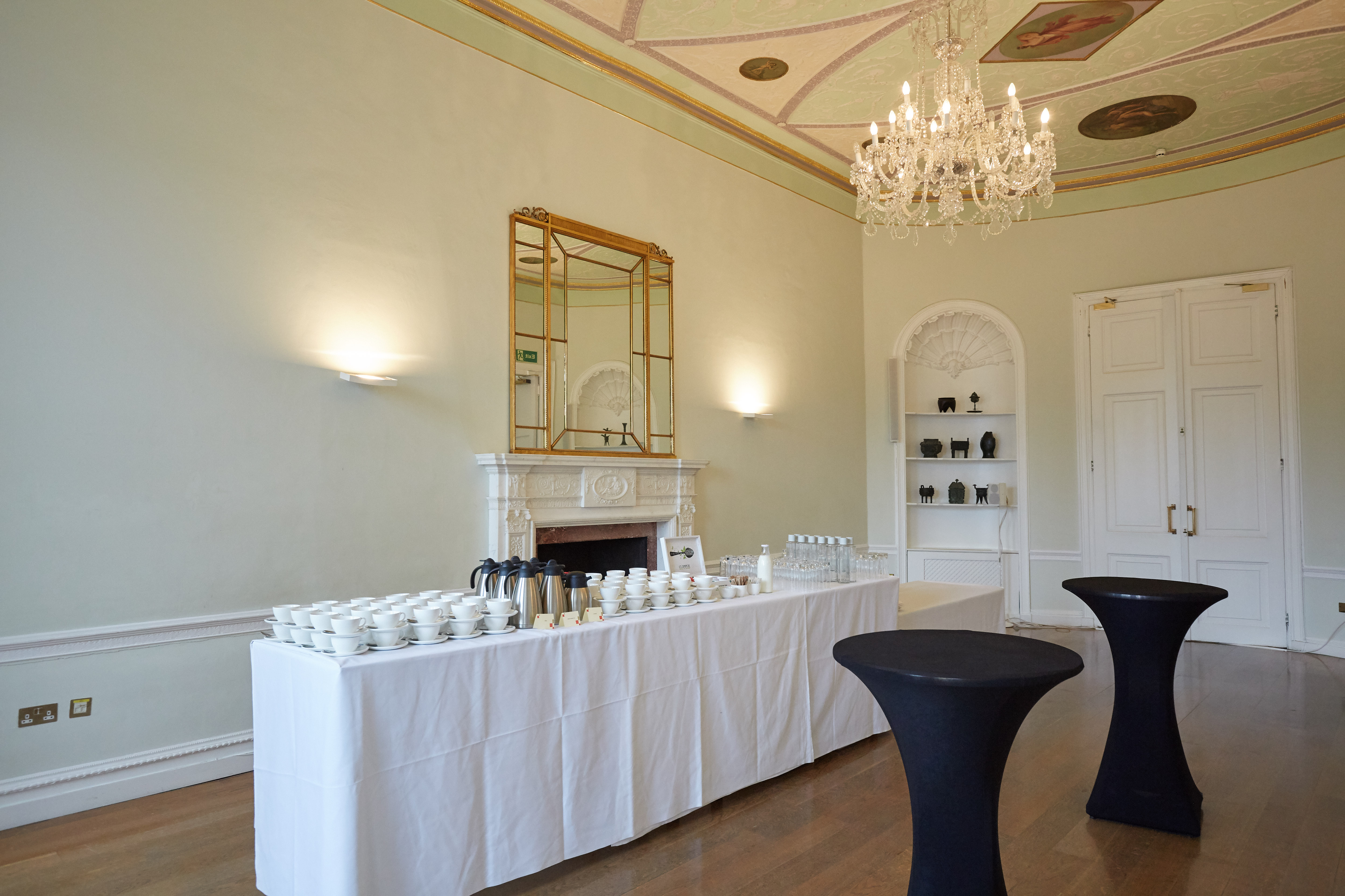 Elegant event space in Asia House with cocktail tables and chandelier for networking.