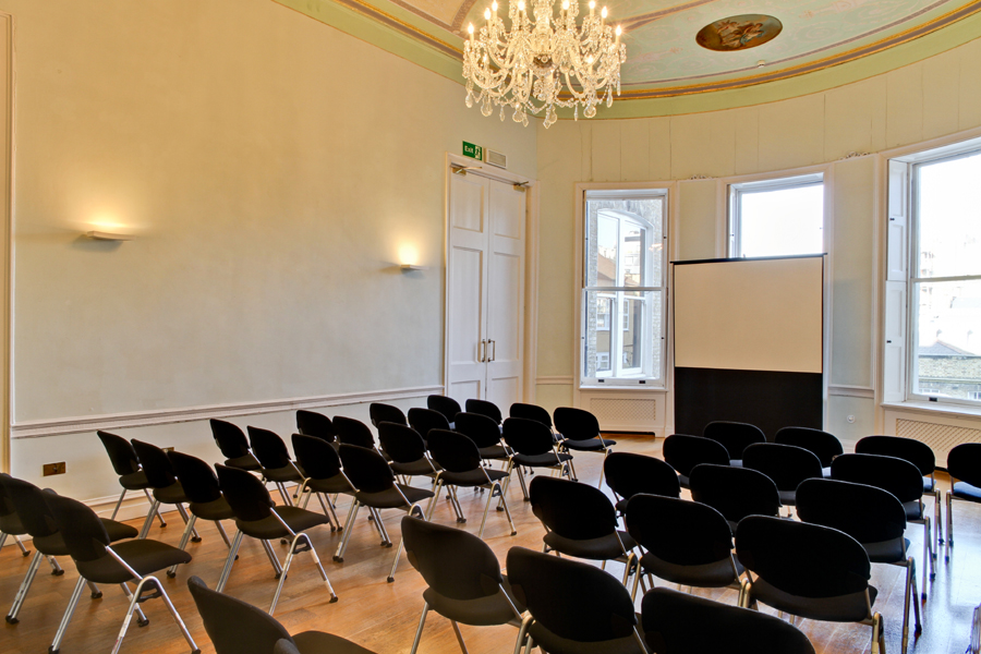 Elegant meeting room with projector screen, ideal for corporate events and presentations.