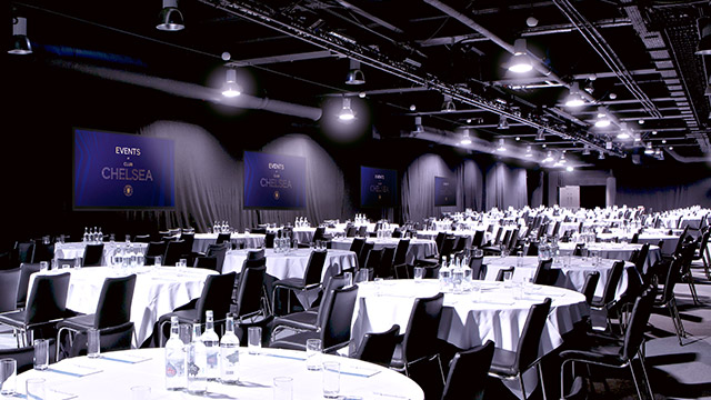 Great Hall at Chelsea FC, elegant venue for corporate events with round tables and screens.