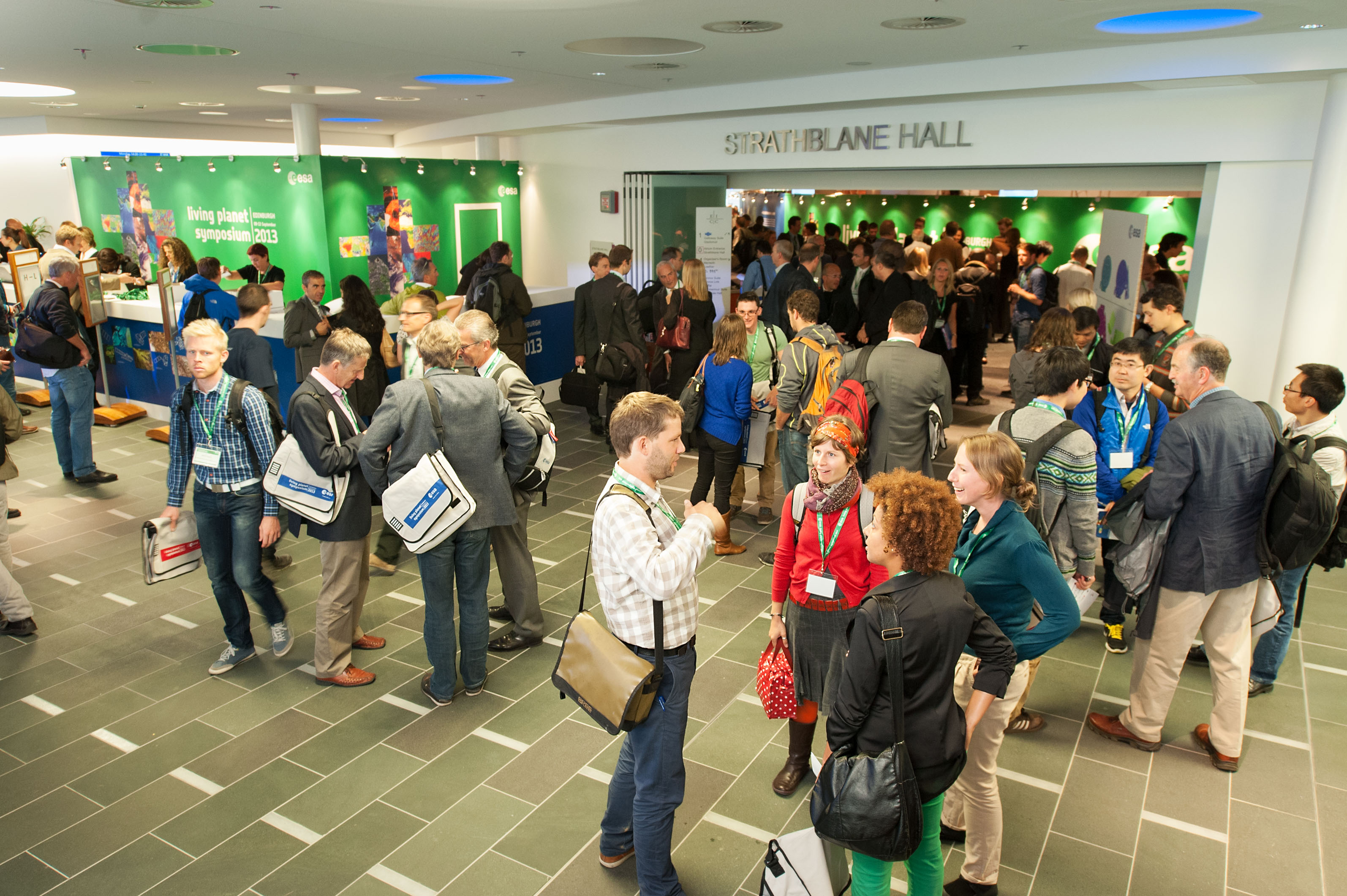 Atrium at Edinburgh Conference Centre, bustling networking event with clear signage.