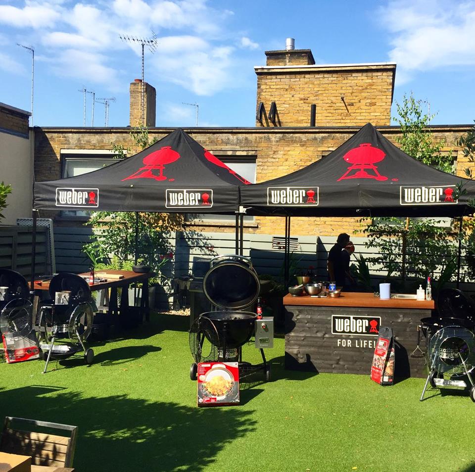 Outdoor networking event with branded tents and grilling stations at 41 Portland Place.
