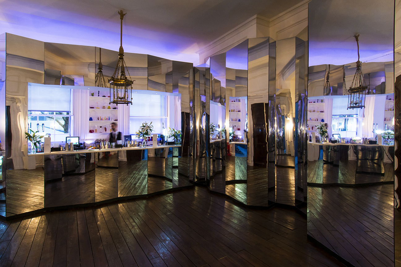 Laurie Landeau in a stylish event space with mirrored walls for networking and gatherings.