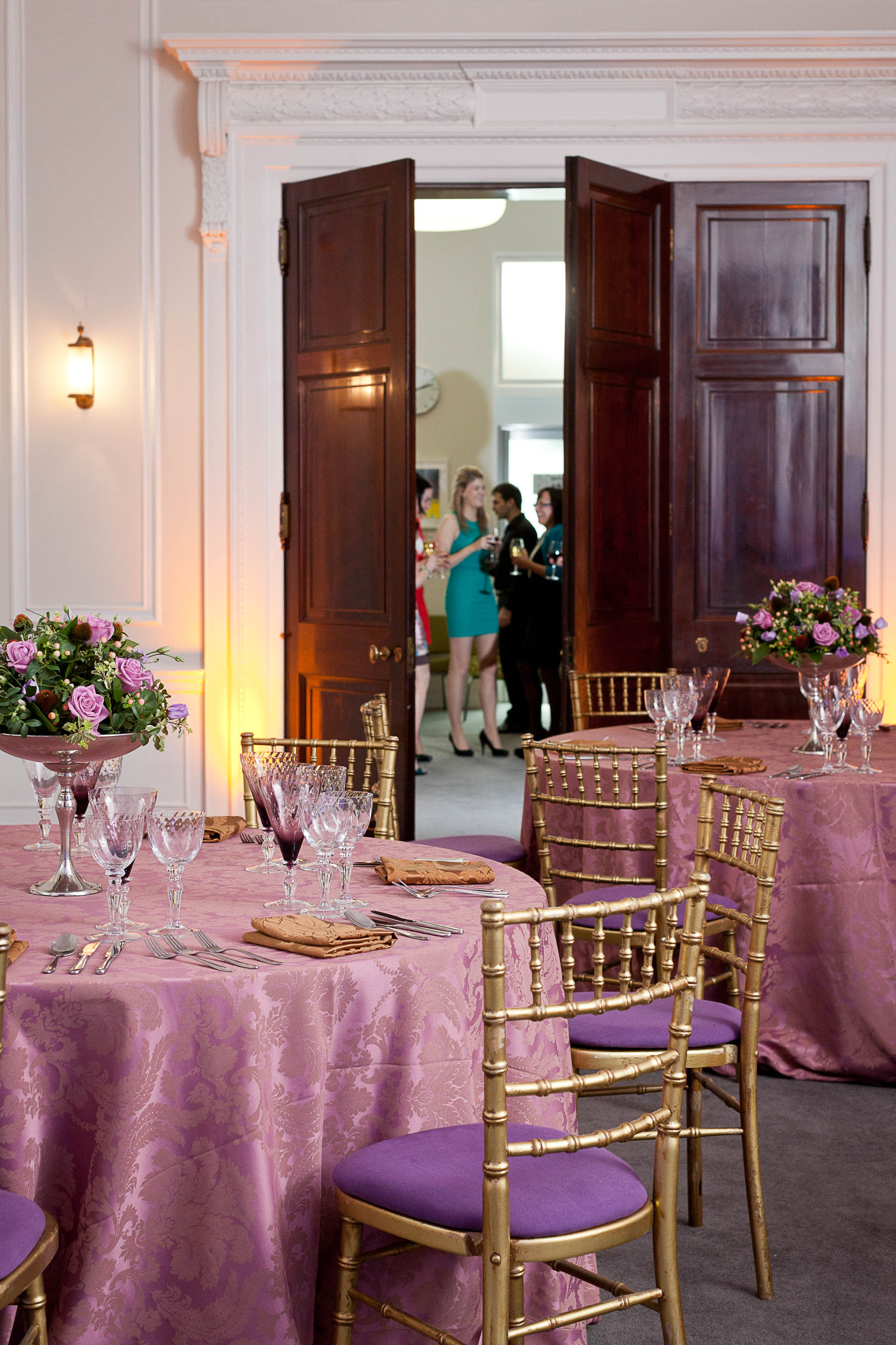 Laurie Landeau in elegant event space with floral decor, perfect for networking and celebrations.