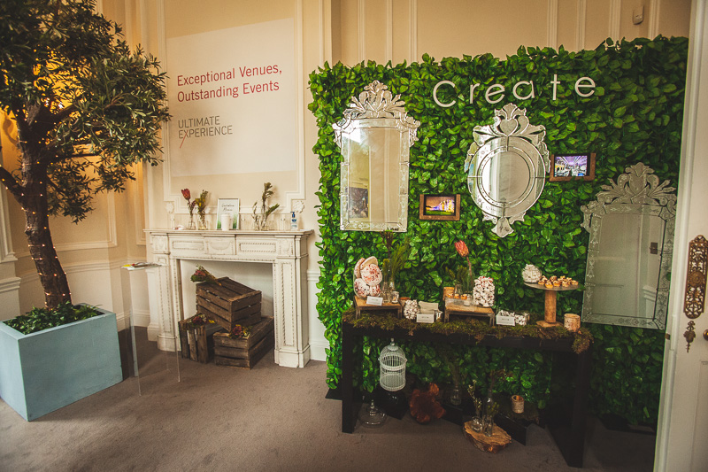 Elegant event space with green wall, ideal for creative gatherings and product showcases.