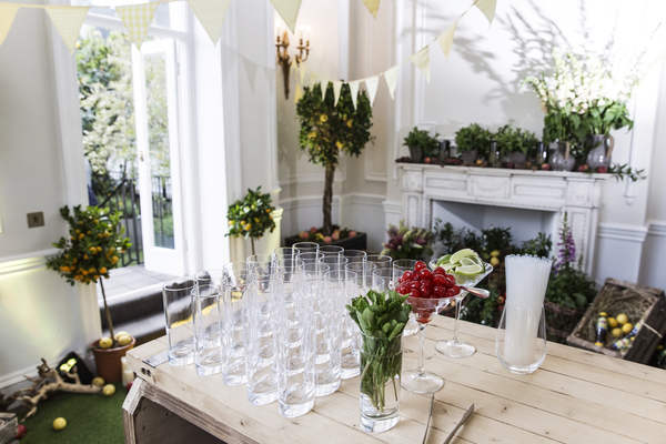 Elegant event space with drink station, greenery, ideal for gatherings and celebrations.
