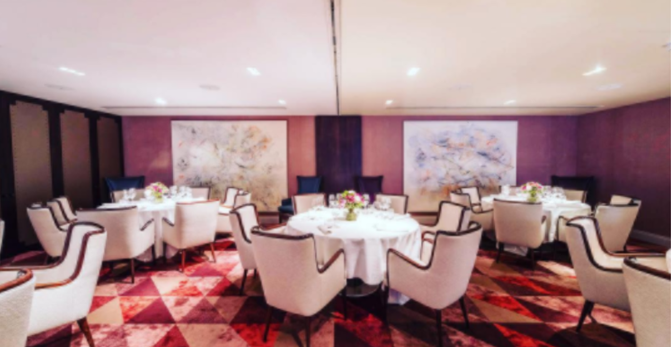 Private dining room in Sartoria with elegant round tables for intimate events and networking.