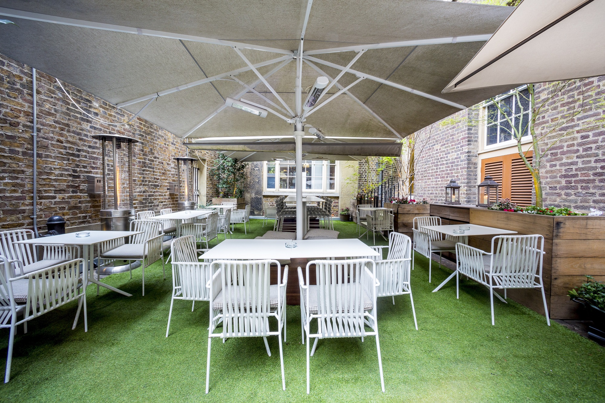 Versatile outdoor event space with modern furniture, ideal for summer gatherings and networking.