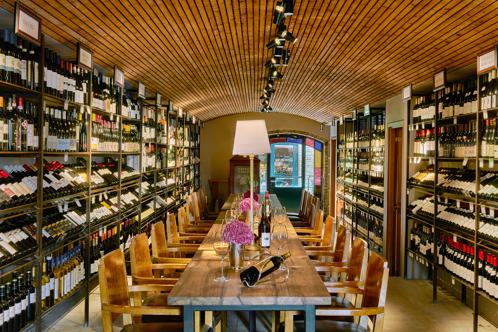 Elegant wine cellar with wooden table, perfect for corporate events and private tastings.